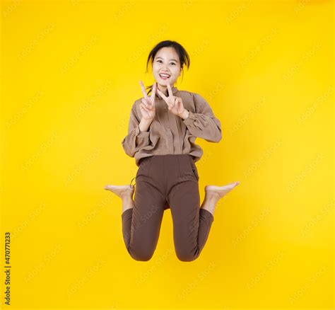 Naughty Pretty Asian Girl Gesture Fingers As Victory Sign While Jumping