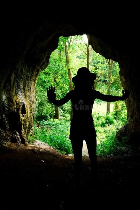 Slim Girl Silhouette At The Entrance To Natural Cave In The Forrest