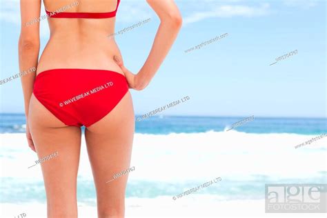 Woman Wearing A Red Bikini Looking At The Sea While Resting Her Hand On