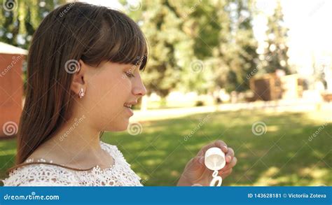 Happy Girl Blowing Beautiful Soap Bubbles In The Park In Spring Summer And Smiling Slow Motion