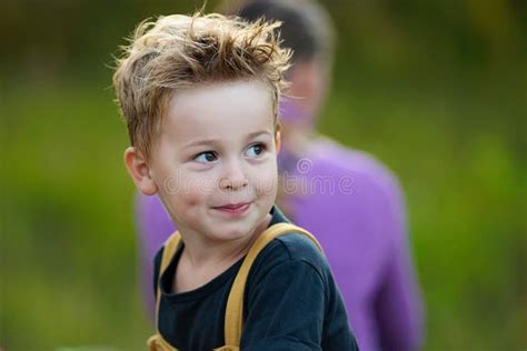 Cute Little Boy With Tousled Hair Looking Aside And Smiling Stock Image