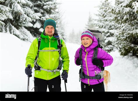 hombre y mujer pareja feliz excursionistas trekking en montañas y bosques de invierno blanco