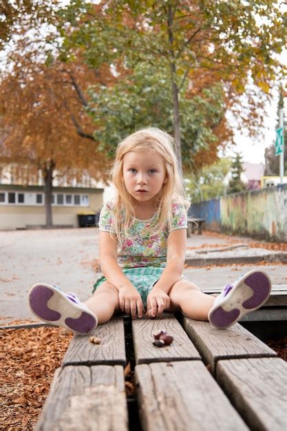 Premium Photo Child Girl Blonde Preschool Age Sits On A Bench