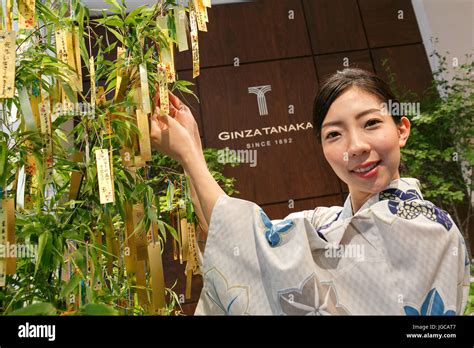 Store Staff Wearing Traditional Japanese Kimono Poses Next To A Bamboo
