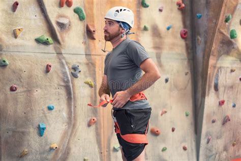 Man Climber Preparing To Climb Artificial Indoor Climbing Wall Stock