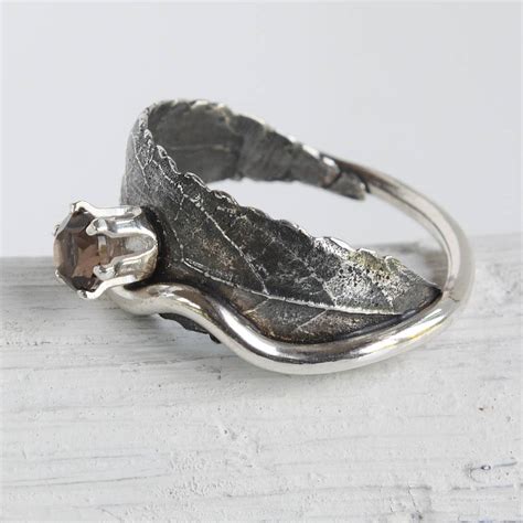 .gold diamond leaf ring featuring shared prong set round and marquise diamonds forming a beautiful leaf leaf ring featuring shared prong set round and marquise diamonds forming a beautiful leaf. handmade silver woodland leaf ring by caroline brook | notonthehighstreet.com