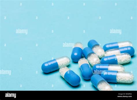 medication capsules spilled on blue pastel coloured background medication and prescription