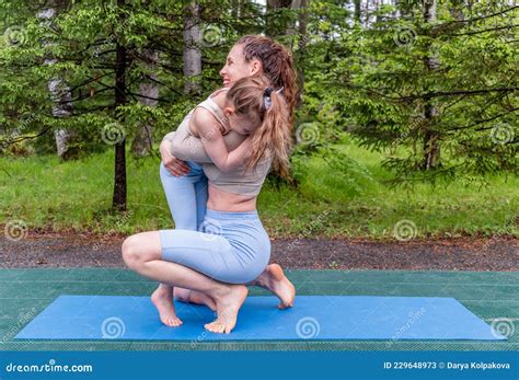Mother And Daughter Doing Yoga On Grass In The Park At The Daytime People Are Having Fun