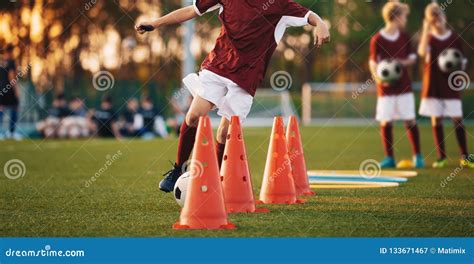 Young Football Players Training On Pitch Soccer Slalom Cone Drill