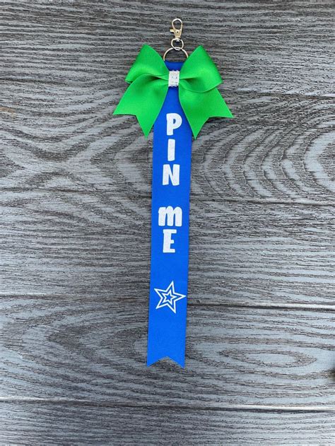 A Ribbon With The Word Pin Me Hanging From Its End On A Wooden Table