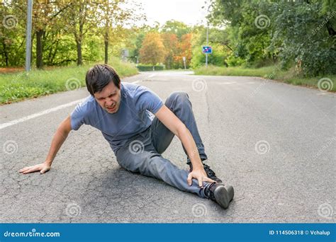 Injured Man Has Broken Leg And Is Sitting On Road Stock Photo Image