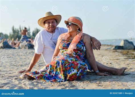 Mature Couple Sitting At Seashore On Summer Sandy Beach Outdoors Background Stock Image Image