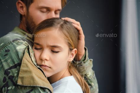 Masculine Sad Military Man Hugging Her Upset Daughter Indoors Stock