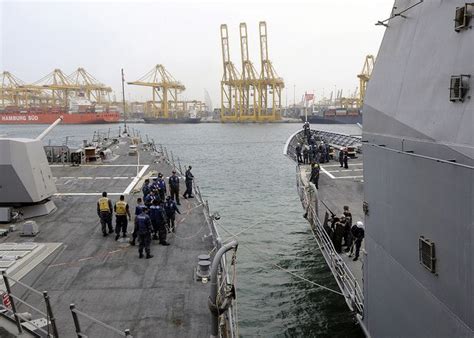 Sailors Take In Lines To Tie The Two Ships Together While Pulling In