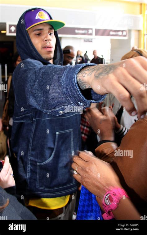Chris Brown Shows His Tattoo While With Fans After Arriving At Ronald