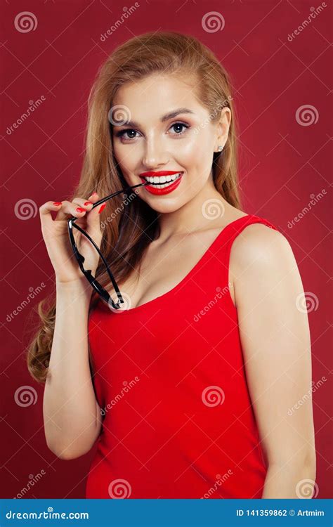 Happy Beautiful Cute Cheerful Girl Holding Sunglasses Smiling And Looking At Camera Over Red