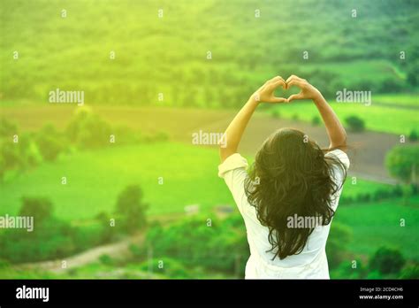 Pretty Woman Holding Hands In Heart Shape Framing Setting During Sunset
