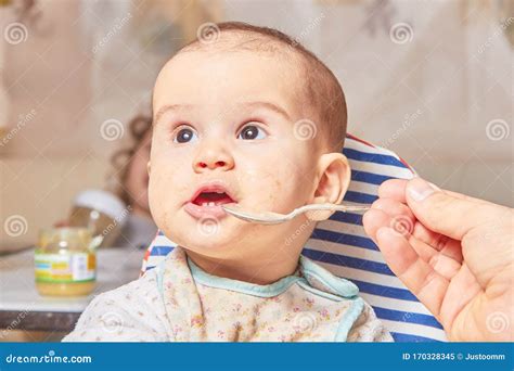 Cute Adorable Baby Eating Porridge With A Spoonful Of The Concept Of