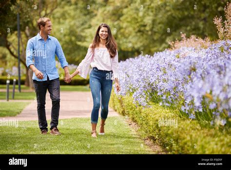 Couple Holding Hands On Romantic Walk In Park Together Stock Photo Alamy