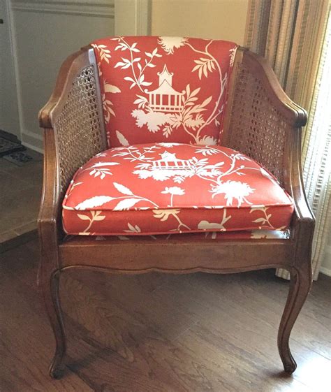An Old Chair With A Red And White Floral Upholstered Seat Sits In Front