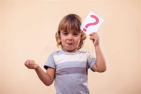 A Portrait Of Kid Boy Holding Cards With Question Mark Childhood And