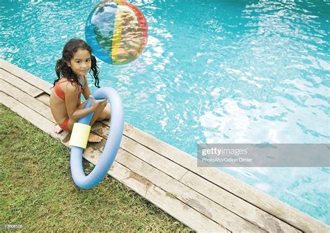 Girl Sitting By Edge Of Pool Holding Floating Ring Bildbanksbilder Getty Images