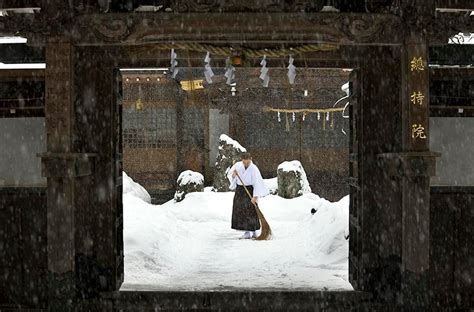 Monk Sweeping Monastery Entrance During Snowfall In Koyasan Japan