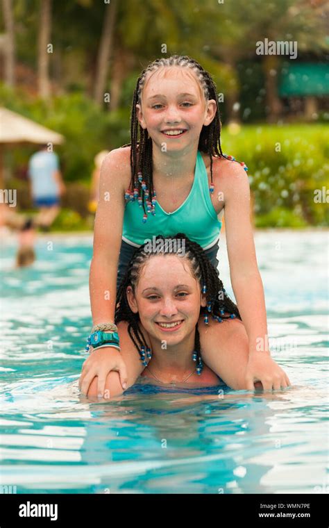 Two Girls Playing Piggy Back While Swimming At A Resort In Cruz Bay On