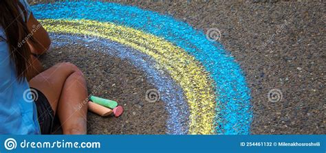 A Child Draws A Rainbow On The Asphalt Selective Focus Stock Photo