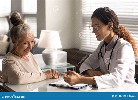 Close Up Smiling Female Doctor Consulting Mature Patient About Contract