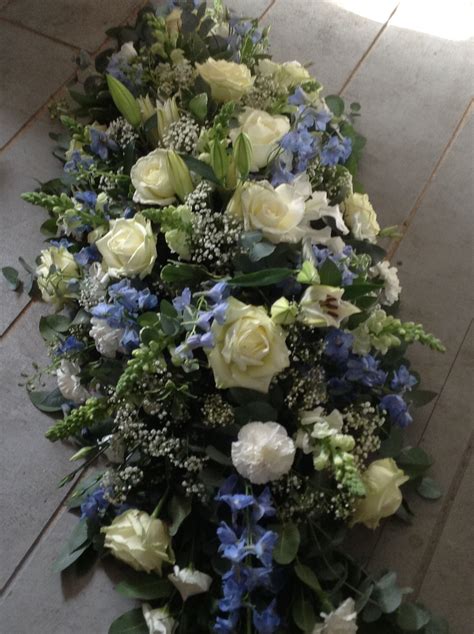 The casket was more beautiful in person than it was in the picture. Blue and white coffin spray, blue delphinium, white roses ...