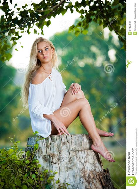 Young Woman Sitting On Stump In The Forest Stock Image