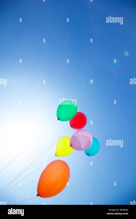 A Bunch Of Colorful Helium Balloons Floating Into The Sky Stock Photo