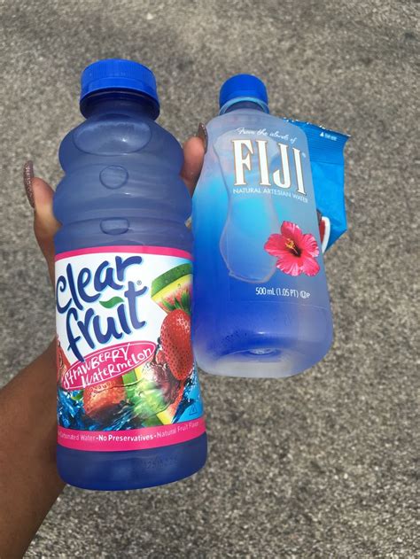 A Person Holding Two Bottles Of Clear Fruit Water