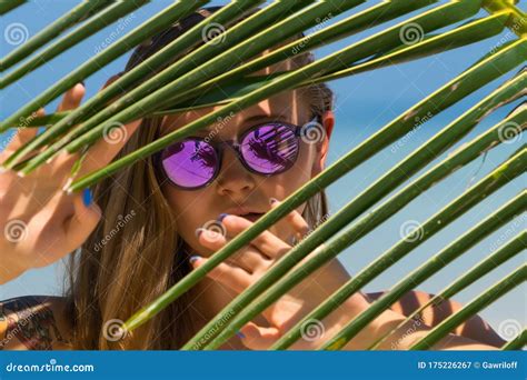 beautiful girl models in a bikini on the sea shore of a tropical island with palm leaf travel