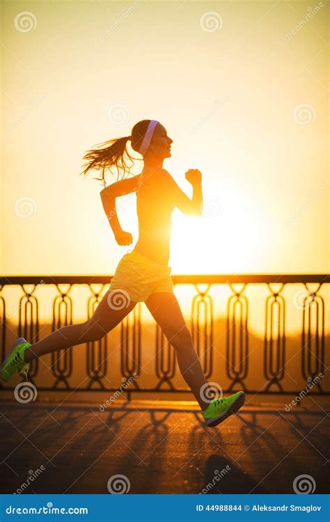 Running Woman Runner Is Jogging In Sunny Bright Light On Sunrise