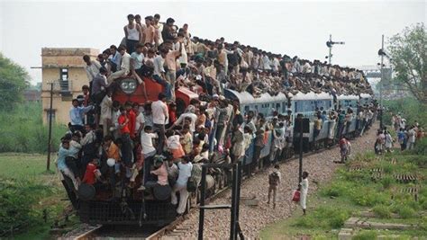 Passengers Clinging Onto A Moving Train In India