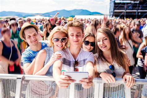 Teenagers At Summer Music Festival In Crowd Taking Selfie Stock Image