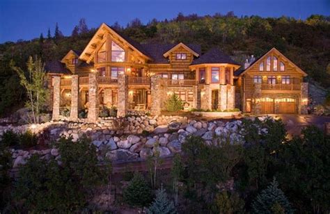 A Large Log Home Lit Up At Night