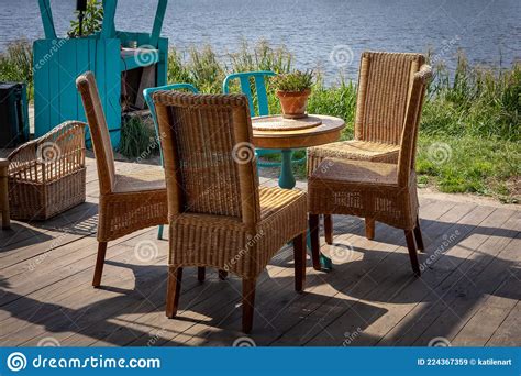 A Wooden Table And Four Wicker Chairs Garden Furniture Standing On A