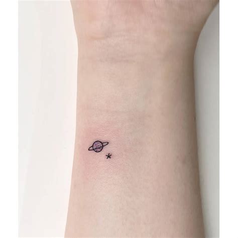 Tiny Minimalistic Saturn And Star Tattoo Located On The