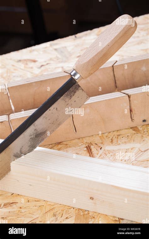 Hand Saw Cutting Through A Beam Of Wood Stock Photo Alamy