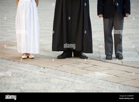 Robed Priest Standing With Formally Dressed Children Stock Photo Alamy
