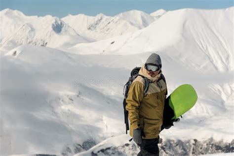Guy In Ski Equipment Is Holding A Green Snowboard Stock Image Image