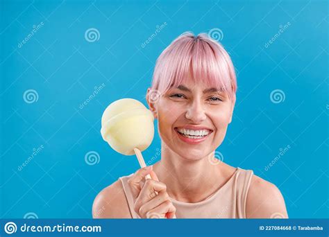 Portrait Of Cheerful Woman With Pink Hair Smiling At Camera And Holding A Big Lollipop Candy Ice