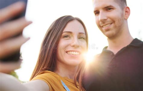 Happy Millenial Couple Taking Selfie Outdoor In Sunset Smiling Friends Using Smartphone In