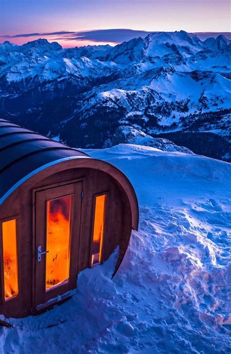 An Outdoor Sauna In The Snow With Mountains In The Background At Sunset Or Dawn