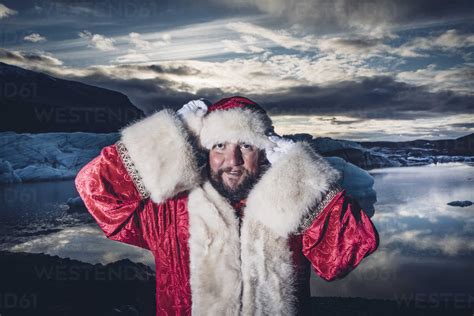 Iceland Portrait Of Santa Claus Standing In Front Of Glacier Stock Photo