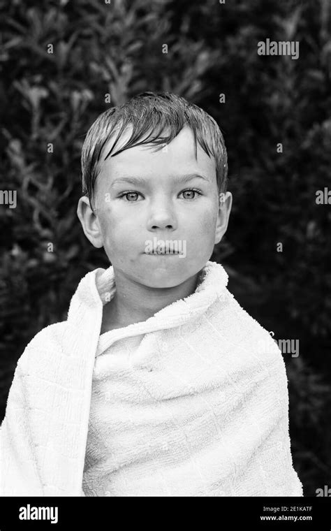 Portrait Of Little Boy Wrapped In A Towel After Bathing Outdoors Black