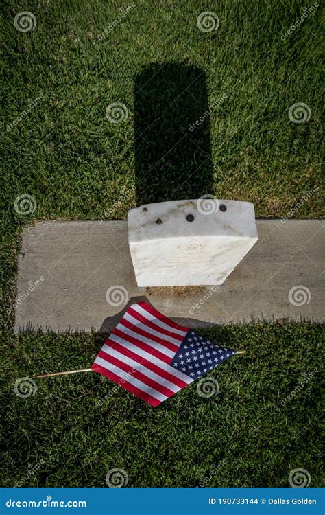 Military Grave Marker Decorated With American Flags For Memorial Day